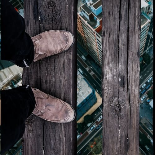 Fear & Phobia Reviews A man on a high bridge looking pas his feet to the street below without fear